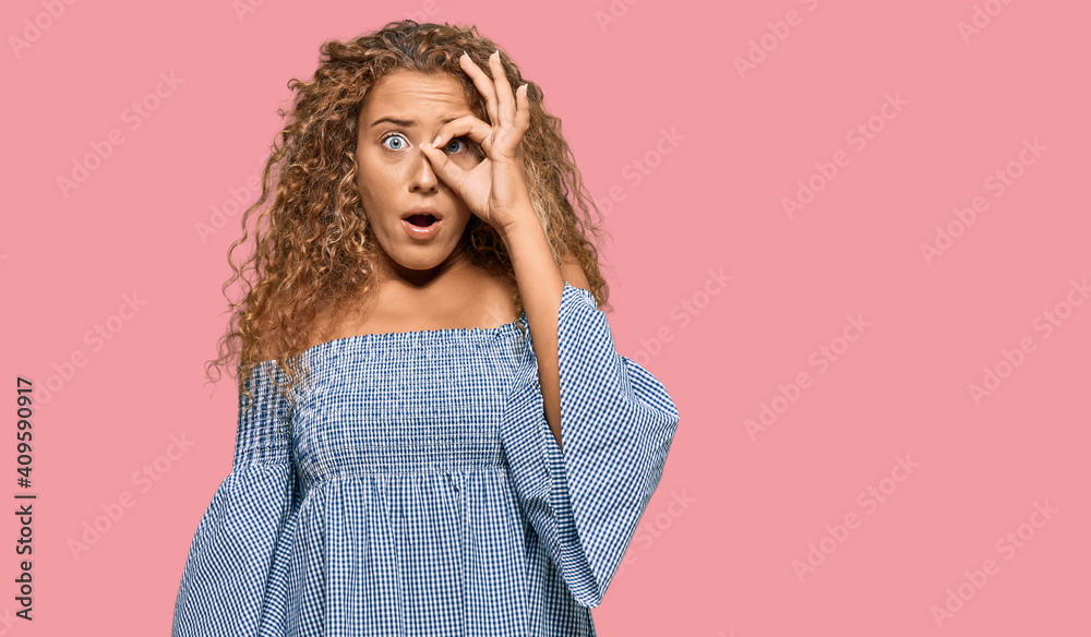 Beautiful caucasian teenager girl wearing summer dress doing ok gesture shocked with surprised face, eye looking through fingers. unbelieving expression. Beautiful caucasian teenager girl wearing summer dress doing ok gesture shocked with surprised face, eye looking through fingers. unbelieving expression.