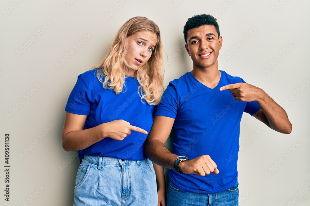 Young interracial couple wearing casual clothes in hurry pointing to watch time, impatience, upset and angry for deadline delay Young interracial couple wearing casual clothes in hurry pointing to watch time, impatience, upset and angry for deadline delay