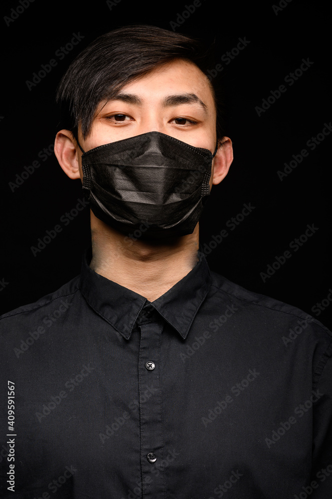 Asian man with medical face mask to protection the coronavirus. Young Asian man living in city with polluted air Asian man with medical face mask to protection the coronavirus. Young Asian man living in city with polluted air