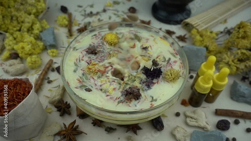 Woman's hand puts ingredients to the glassware for preparation domestic cosmetics in slow motion. Alternative medicine, organic cosmetics, aromatherapy and natural care concept.