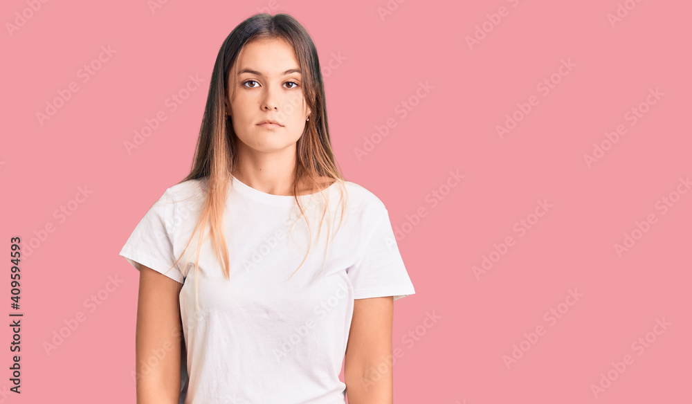 Beautiful caucasian woman wearing casual white tshirt relaxed with serious expression on face. simple and natural looking at the camera. Beautiful caucasian woman wearing casual white tshirt relaxed with serious expression on face. simple and natural looking at the camera.