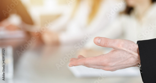 Business presentation. Businessman giving speech to colleagues and partners at corporate meeting or conference  close-up of speaker hands