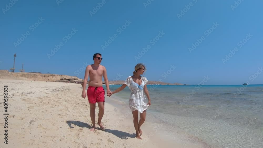Romantic Couple on Honeymoon walking on Shallow Tropical Ocean Sandbar, Giftun island, Paradise beach, Hurghada, Egypt Romantic Couple on Honeymoon walking on Shallow Tropical Ocean Sandbar, Giftun island, Paradise beach, Hurghada, Egypt
