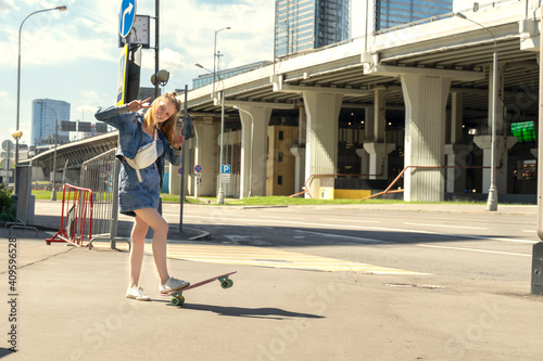 cheerful teen girl with a skate on the street