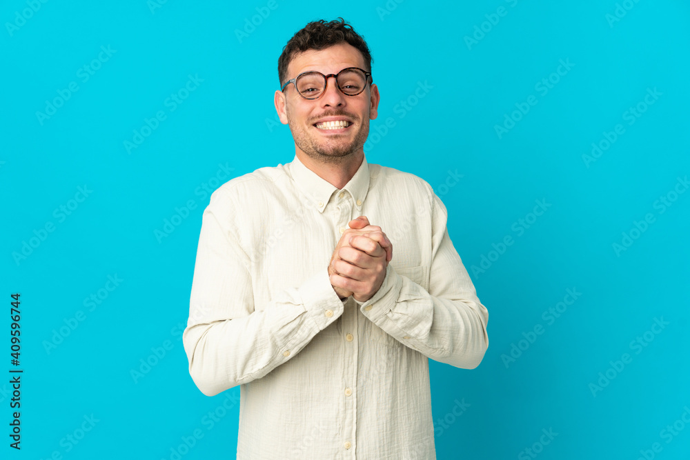Young caucasian handsome man isolated on blue background laughing Young caucasian handsome man isolated on blue background laughing