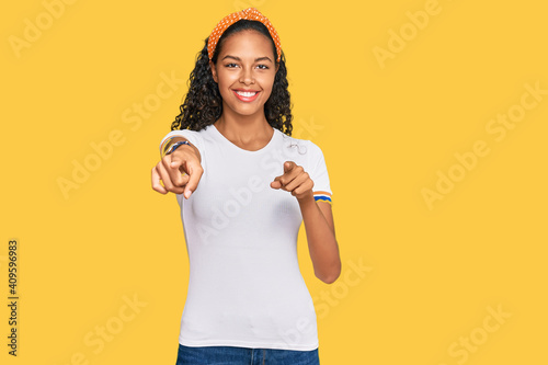 Obraz na plátně Young african american girl wearing casual clothes pointing to you and the camer