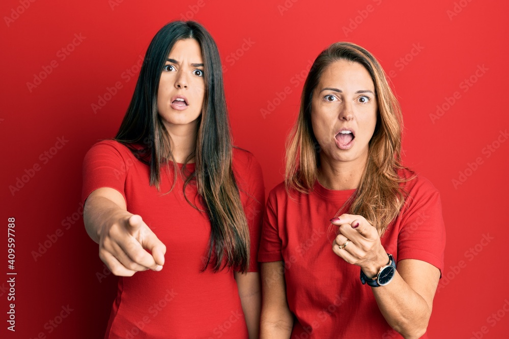 Hispanic family of mother and daughter wearing casual clothes over red background pointing displeased and frustrated to the camera, angry and furious with you Hispanic family of mother and daughter wearing casual clothes over red background pointing displeased and frustrated to the camera, angry and furious with you