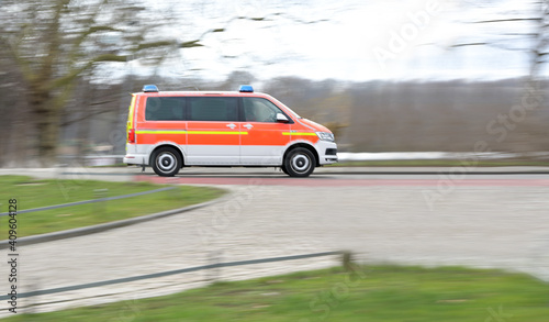 Panning of an ambulance car driving by at high speed, motion blur, copy space