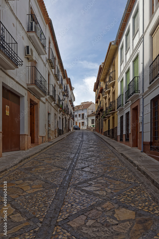 A narrow decoratively cobbled Street in the medieval town of Antequerra in Andalucia on a quiet evening in May.