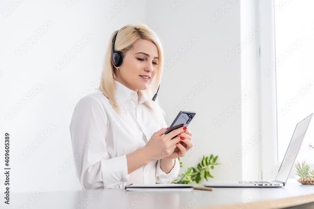 Portrait of a smiling young woman using laptop and smartphone Portrait of a smiling young woman using laptop and smartphone