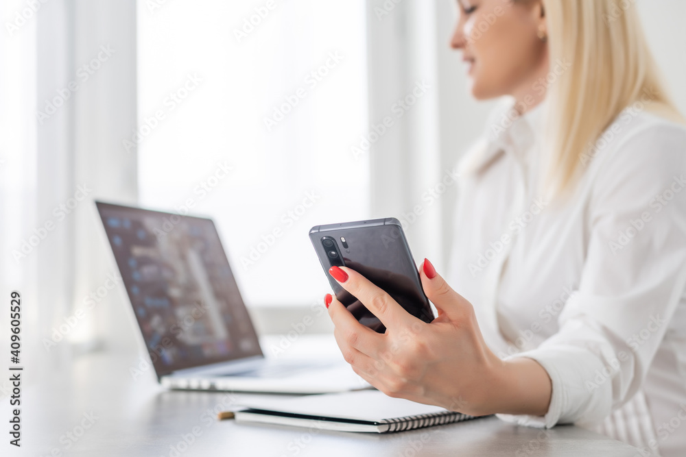 Portrait of a smiling young woman using laptop and smartphone Portrait of a smiling young woman using laptop and smartphone