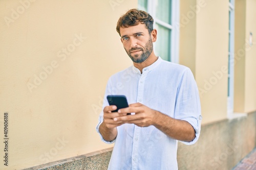 Canvas Print Handsome man with beard wearing casual white shirt on a sunny day smiling happy