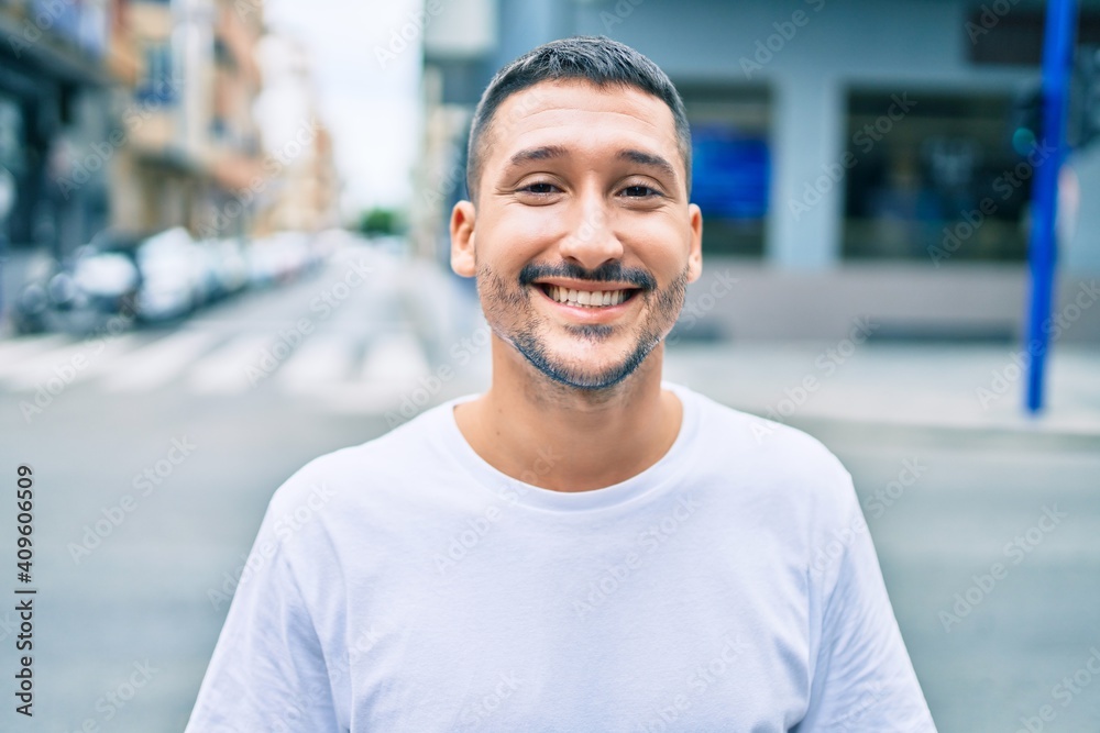 Young hispanic man smiling happy walking at street of city. Young hispanic man smiling happy walking at street of city.