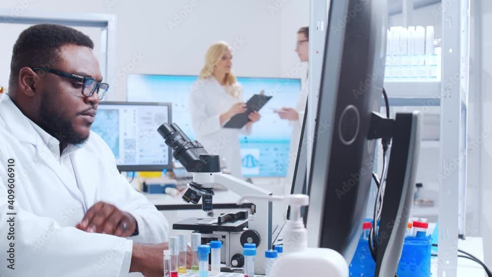 Professional team of scientists is working on a vaccine in a modern scientific research laboratory. Genetic engineer workplace. Futuristic technology and science concept.