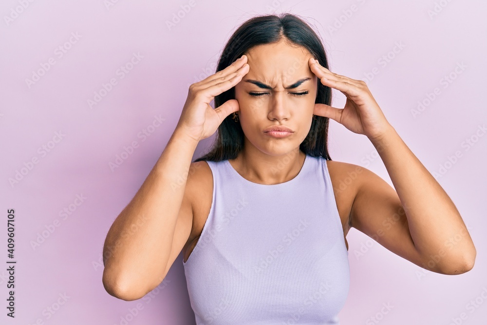 Young brunette woman wearing casual clothes with hand on head, headache because stress. suffering migraine. Young brunette woman wearing casual clothes with hand on head, headache because stress. suffering migraine.