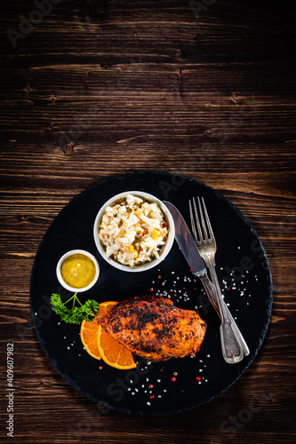 Stuffed chicken breast and coleslaw on wooden table
