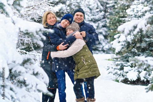 family portrait in the winter forest, parent and children, beautiful nature with bright snowy fir trees