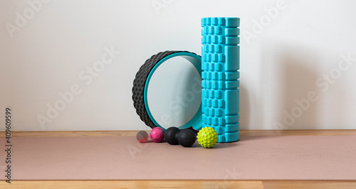 SMR roller and balls - fitness tools on wooden floor with a pink yoga mat (self-myofascial release) photo
