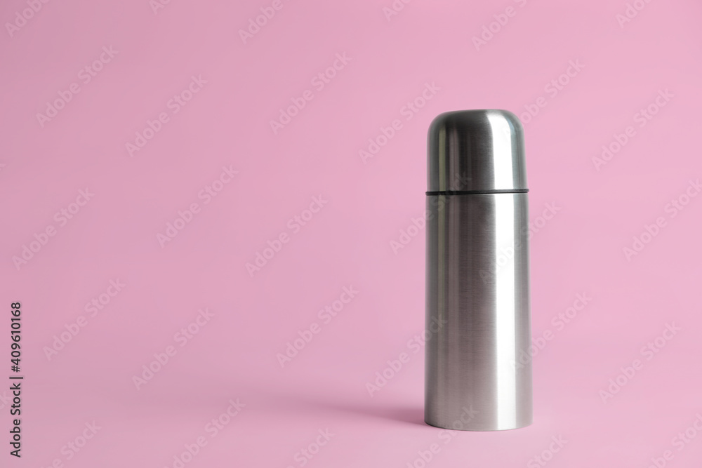 Stylish thermo bottle on pink background, space for text Stylish thermo bottle on pink background, space for text