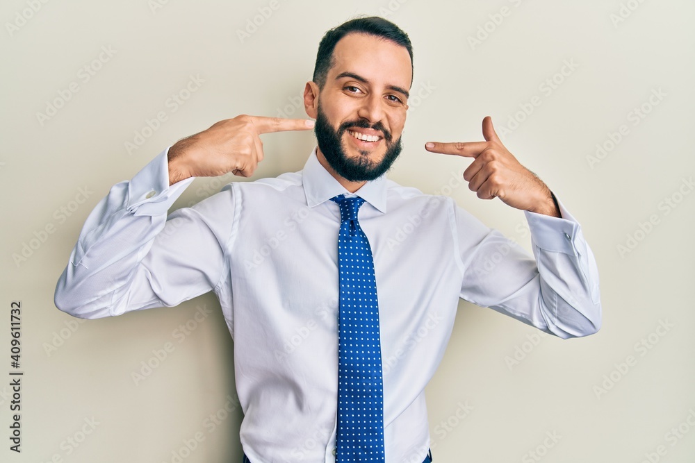 Young man with beard wearing business tie smiling cheerful showing and pointing with fingers teeth and mouth. dental health concept. Young man with beard wearing business tie smiling cheerful showing and pointing with fingers teeth and mouth. dental health concept.