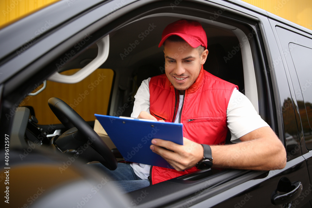 Courier with clipboard on driver's seat of car Courier with clipboard on driver's seat of car