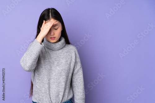 Young asian woman over isolated background with headache © luismolinero