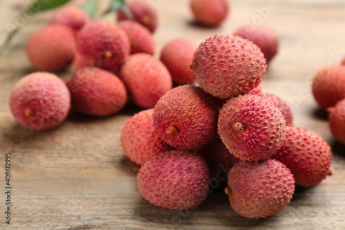 Fresh ripe lychees on wooden table, closeup. space for text