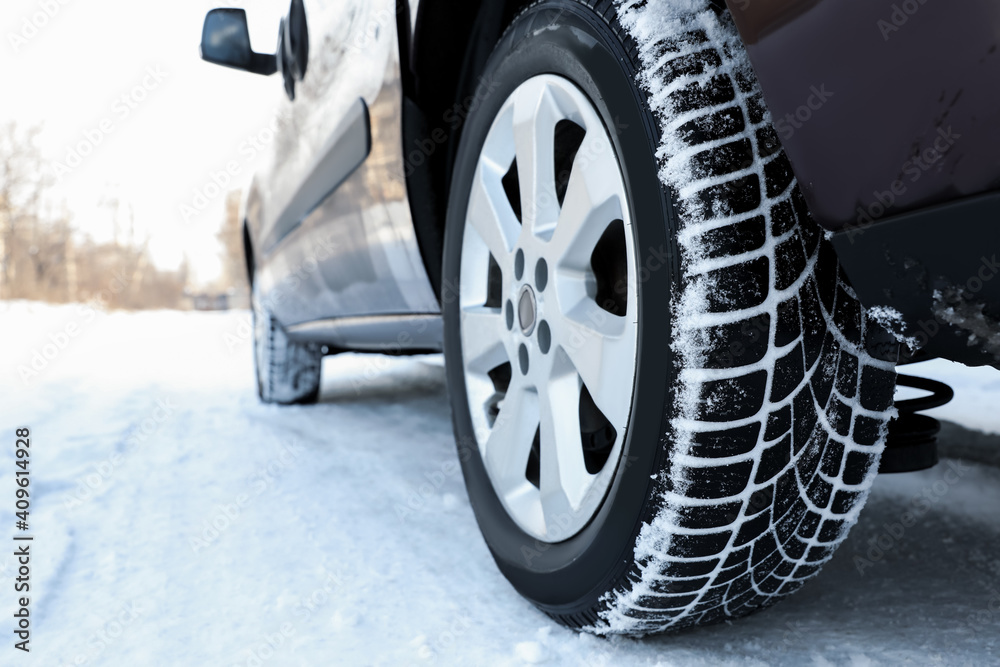 Car with winter tires on snowy road, closeup view Car with winter tires on snowy road, closeup view