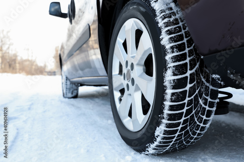 Car with winter tires on snowy road, closeup view © New Africa