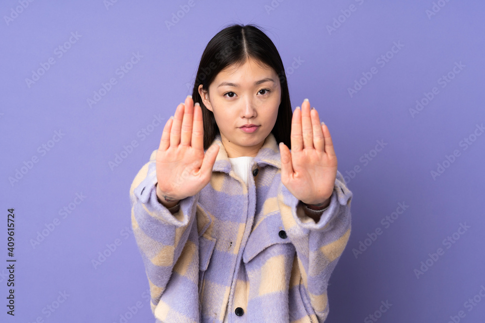 Young asian woman isolated on purple background making stop gesture and disappointed Young asian woman isolated on purple background making stop gesture and disappointed