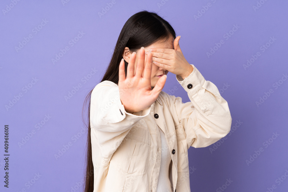 Young asian woman isolated on purple background making stop gesture and covering face Young asian woman isolated on purple background making stop gesture and covering face