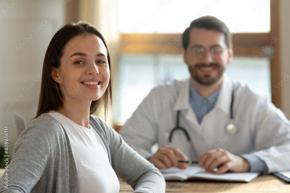 Happy millennial Caucasian female patient feel satisfied pleased with good hospital medical service after consultation with doctor. Portrait of smiling woman client consult with GP in private clinic.