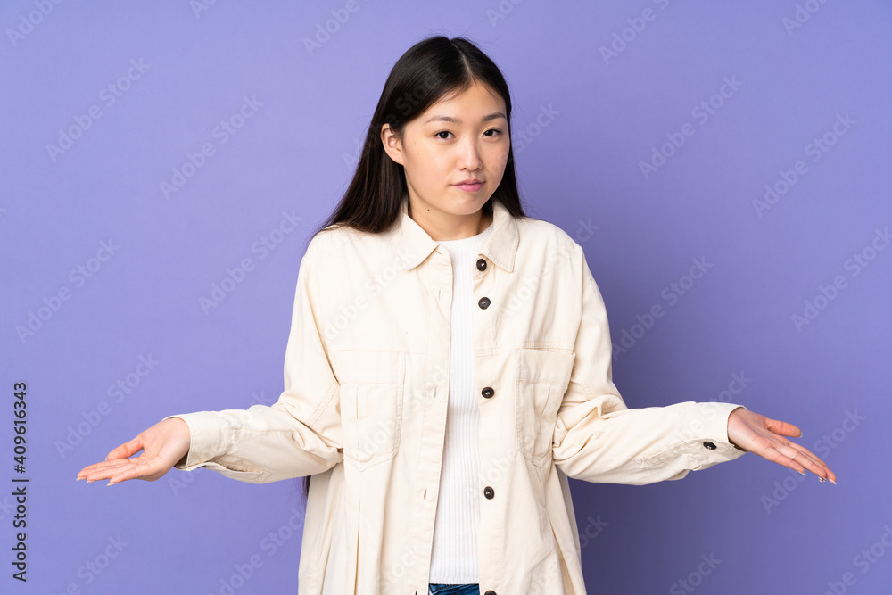Young asian woman isolated on purple background having doubts Young asian woman isolated on purple background having doubts