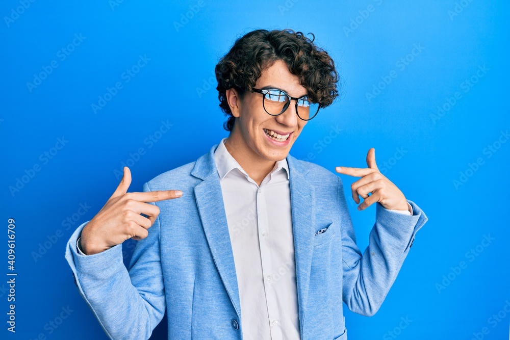 Hispanic young man wearing business jacket and glasses looking confident with smile on face, pointing oneself with fingers proud and happy. Hispanic young man wearing business jacket and glasses looking confident with smile on face, pointing oneself with fingers proud and happy.