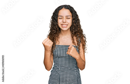 Teenager hispanic girl wearing casual clothes very happy and excited doing winner gesture with arms raised, smiling and screaming for success. celebration concept.