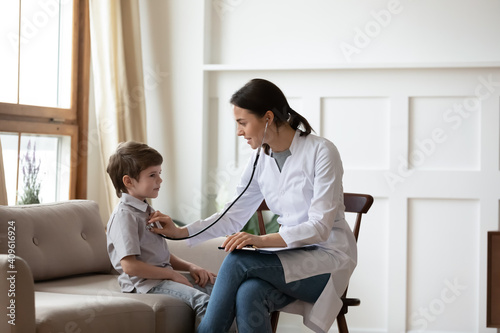Wallpaper Mural Caring female pediatrician or GP listen to small boy child patient chest with stethoscope at consultation in hospital. Attentive woman doctor examine little kid in clinic. Children healthcare concept. Torontodigital.ca
