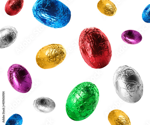 Falling chocolate eggs wrapped in bright foil on white background