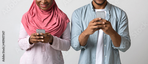 Cropped of addicted black couple using mobile phones