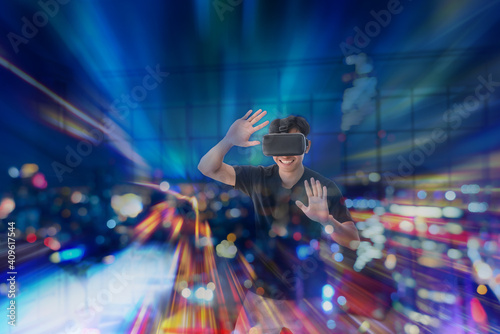 Young Asian man getting experience with VR virtual reality headset or 3D glasses in living room at home. technology, gaming, entertainment concept © bigy9950