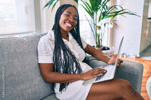 Young african american woman smiling happy working using laptop at home