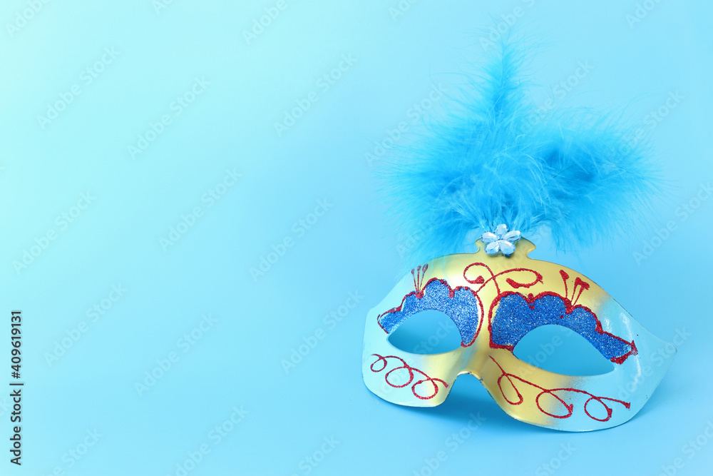 Photo of elegant and delicate Venetian mask over blue background