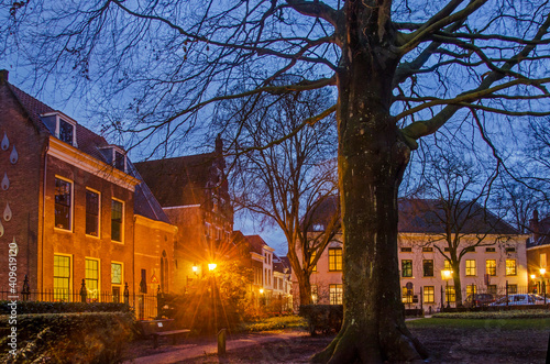Gouda, The Netherlands, December 30, 2020: the garden behind St. John's church, surrounded by historic buildings during the blue hour after sunset
