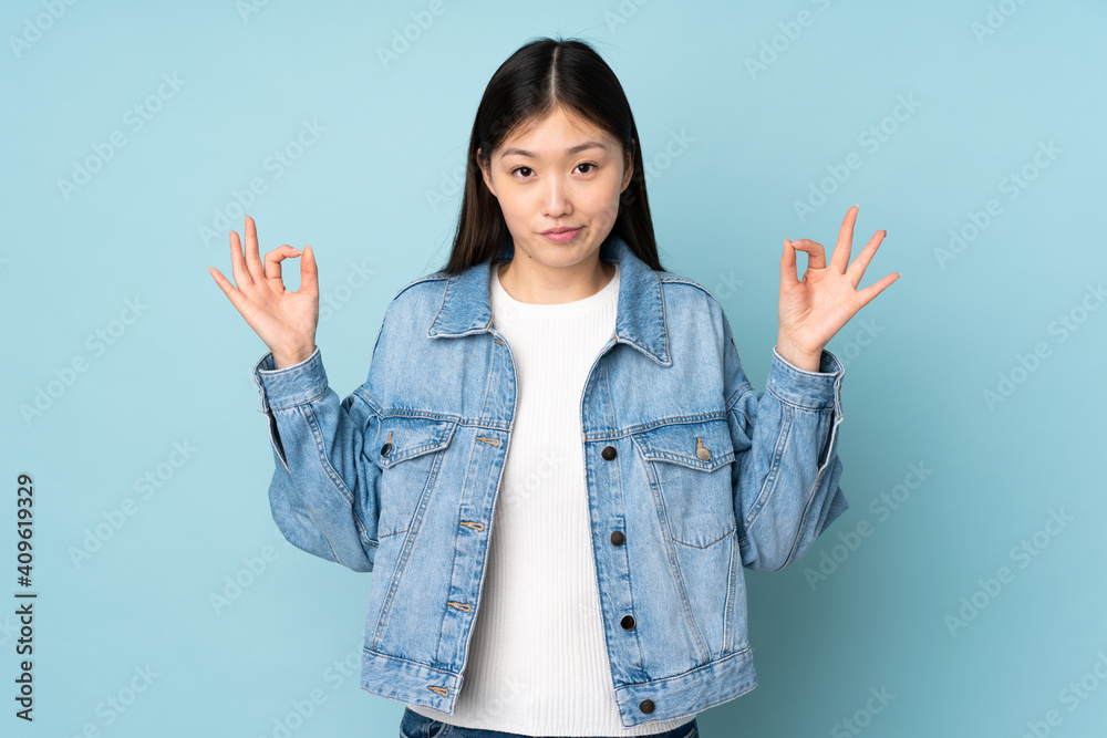 Young asian woman isolated on background in zen pose Young asian woman isolated on background in zen pose