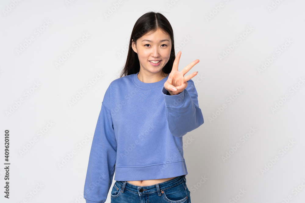Young asian woman isolated on background happy and counting three with fingers Young asian woman isolated on background happy and counting three with fingers