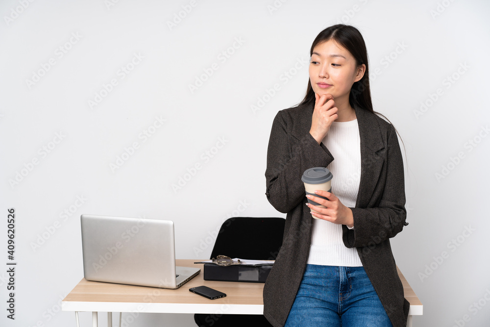 Business asian woman in her workplace isolated on white background looking to the side Business asian woman in her workplace isolated on white background looking to the side