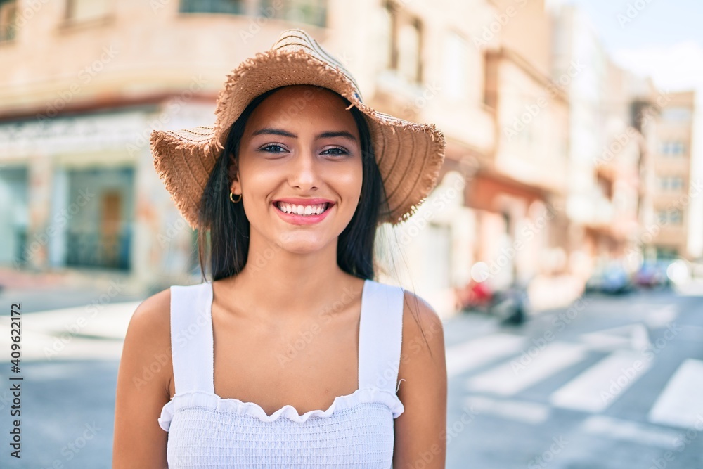 Young latin girl wearing summer style and smiling happy at street of city.