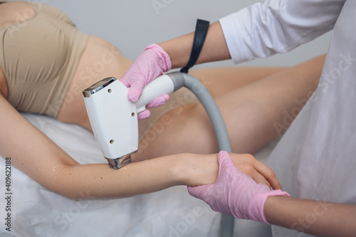 Laser epilation and cosmetology in beauty salon. Hair removal procedure. Laser epilation, cosmetology, spa, and hair removal concept. Beautiful blonde woman getting hair removing on arms.