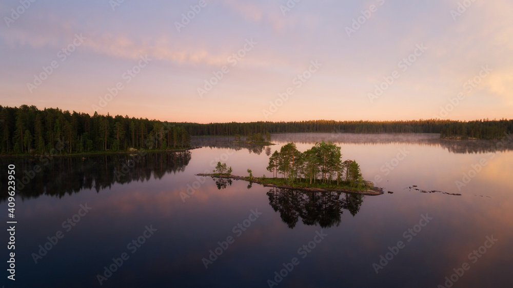 Aerial view of small island in the lake in summer at sunset. Travel destinations concept, environmental conservation theme.