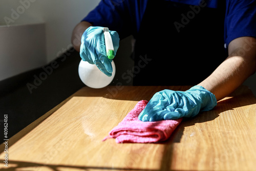 Staff cleaning on restaurant tables, he injects detergent and uses pink tablecloths to clean, cleaning to prevent COVID-19 transmission, COVID-19 prevention concept.