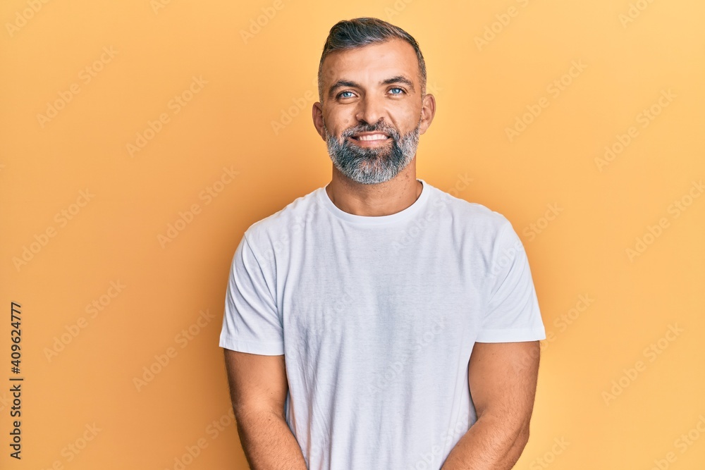 Middle age handsome man wearing casual white tshirt with a happy and cool smile on face. lucky person. Middle age handsome man wearing casual white tshirt with a happy and cool smile on face. lucky person.